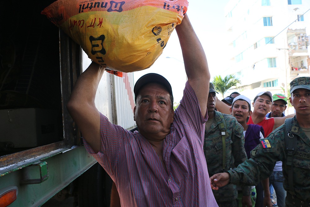 Don Carlos ayuda a descargar y repartir donaciones provenientes del cantón Samborondón | Foto: M. Ayala