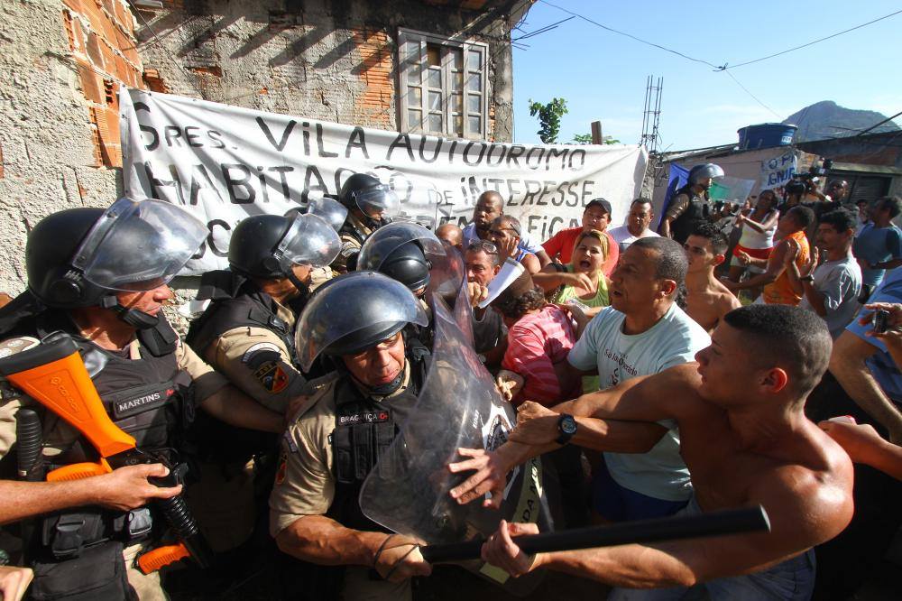 Luiz Claudio da Silva (camiseta blanca) junto a otros habitantes impiden la invasión por parte de la Policía Militar. | Foto: Reproducción Página Oficial Vila Autódromo.
