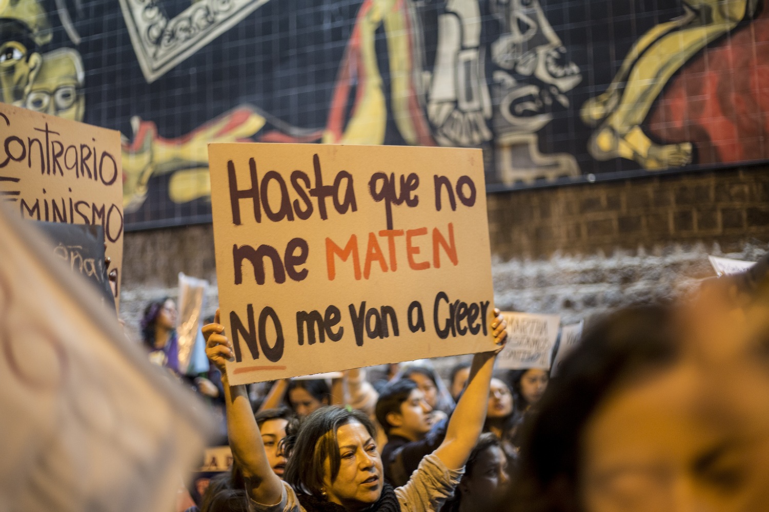 Una mujer sostiene un cartel frente al mural que adorna la fachada sur de la Fiscalía General del Estado en Quito. Tras el ataque, Martha fue hallada inconsciente y desnuda en el baño del local. Según su abogado, ella tenía sangre en sus partes ínti…